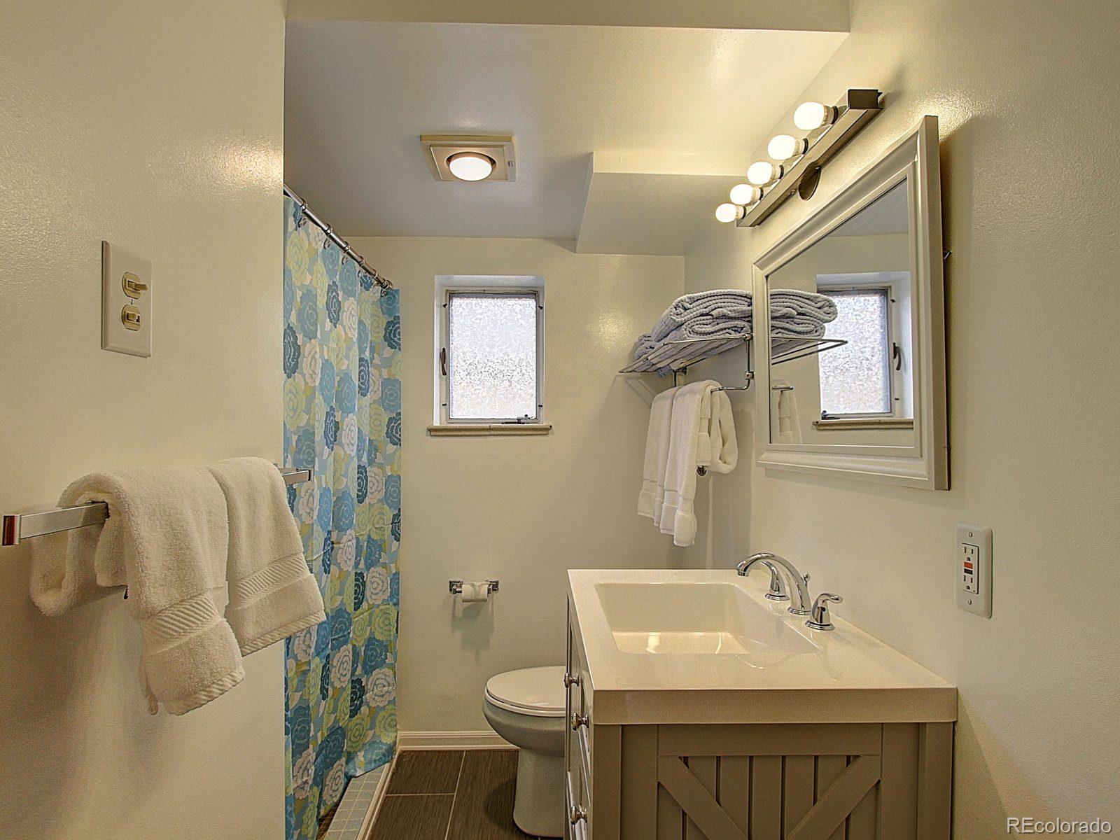 3840 Pierce Street Wheat Ridge, CO 80033 - Photo 22 of 32 a bathroom with a sink toilet and mirror