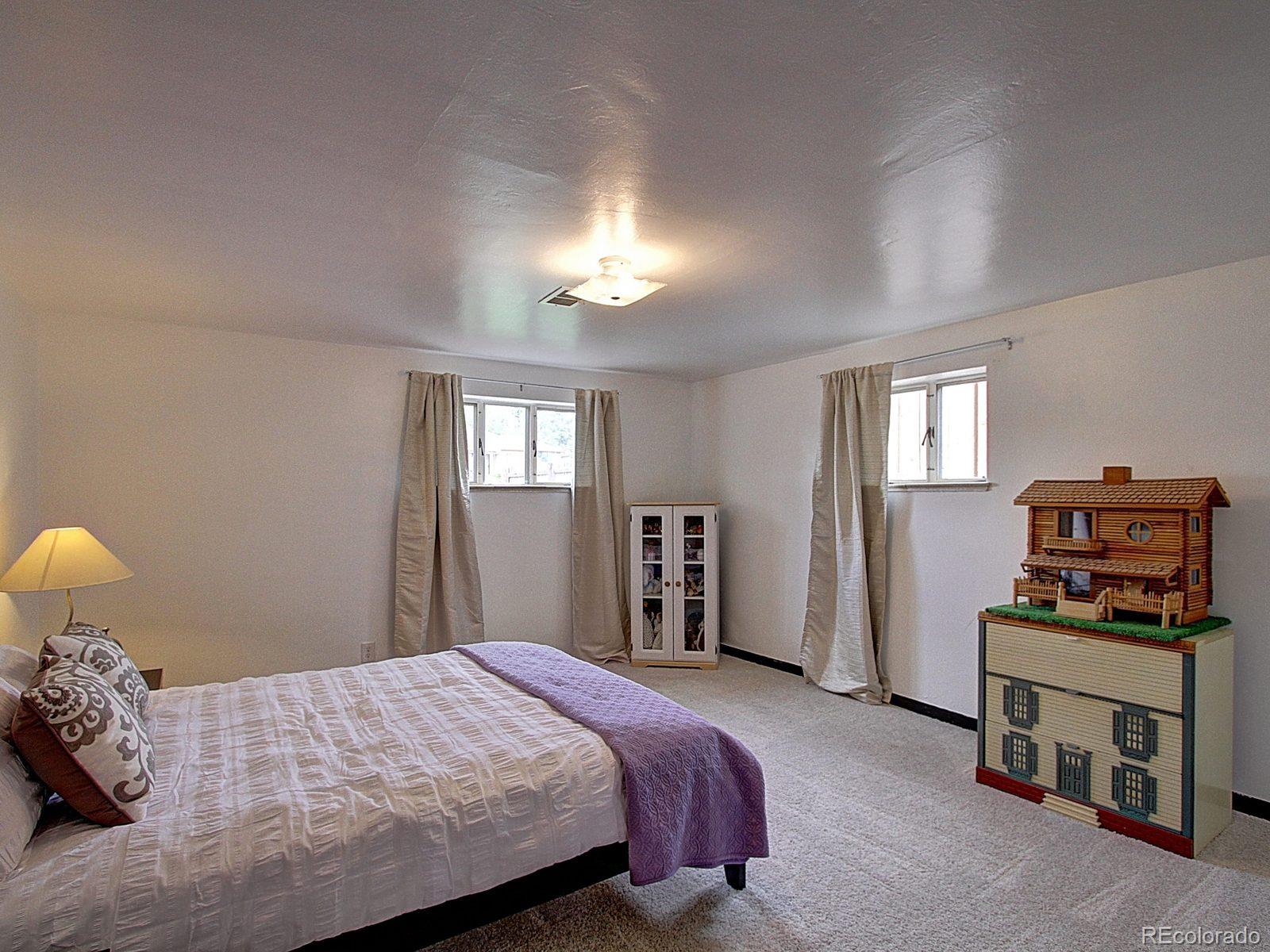 3840 Pierce Street Wheat Ridge, CO 80033 - Photo 23 of 32 a bedroom with a bed and a chandelier