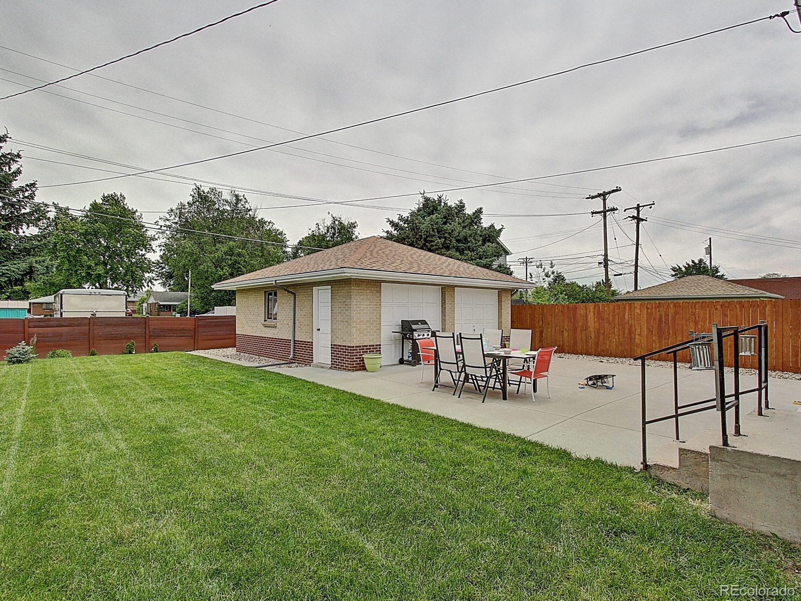 3840 Pierce Street Wheat Ridge, CO 80033 - Photo 27 of 32 a view of a patio with table and chairs under an umbrella