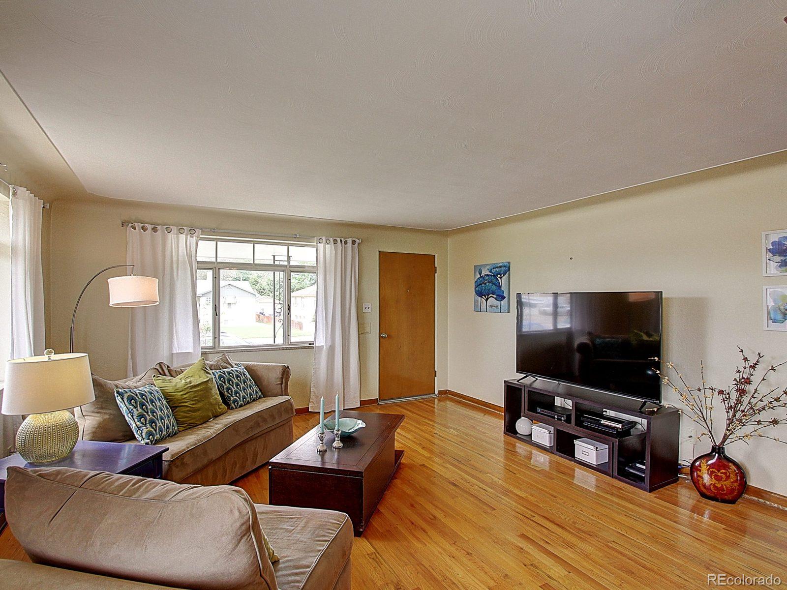 3840 Pierce Street Wheat Ridge, CO 80033 - Photo 7 of 32 a living room with furniture and a flat screen tv