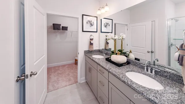 a bathroom with a granite countertop sink a mirror a vanity and a shower