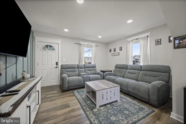 a kitchen with stainless steel appliances granite countertop a sink dishwasher stove and white cabinets with wooden floor