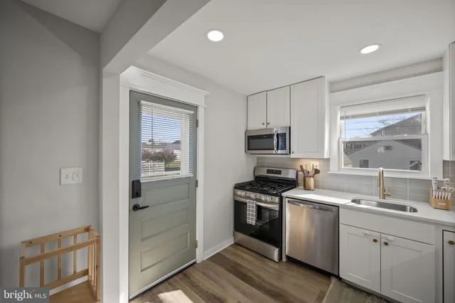 a kitchen with white cabinets and appliances