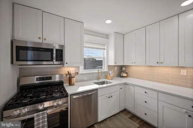 a kitchen with white cabinets and white appliances