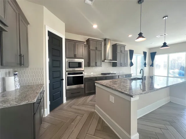 a kitchen with stainless steel appliances granite countertop a sink stove and refrigerator