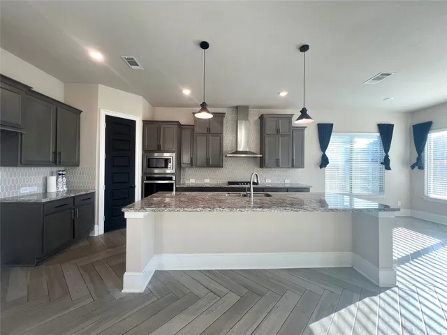 a large kitchen with a large counter top appliances and cabinets