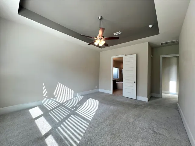 a view of a livingroom with a chandelier fan and wooden floor