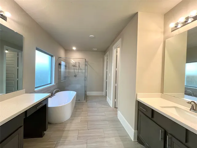 a bathroom with a double vanity sink a toilet a mirror and shower