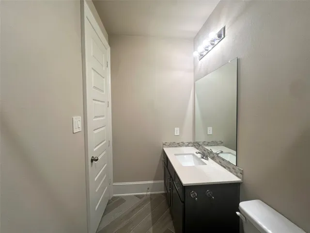 a bathroom with a sink a toilet and mirror