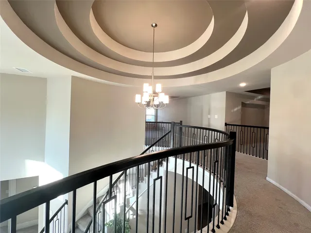 a view of a hallway with a chandelier and furniture