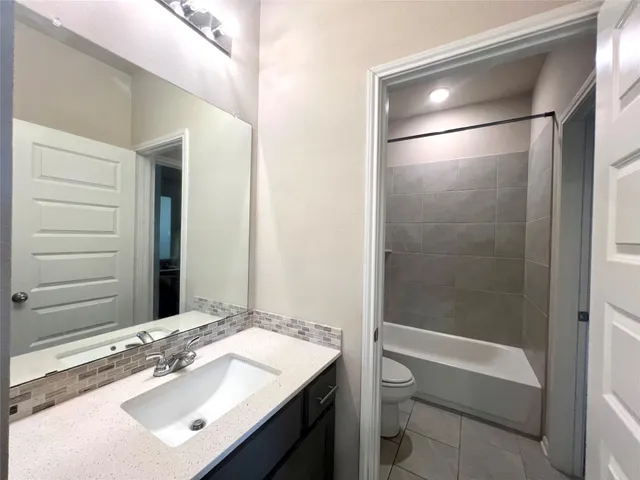 a bathroom with a sink a toilet a mirror and shower curtain