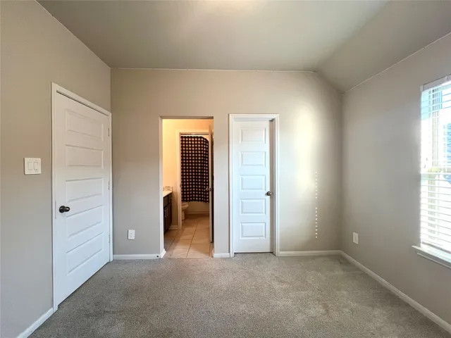 an empty room with an entryway and window