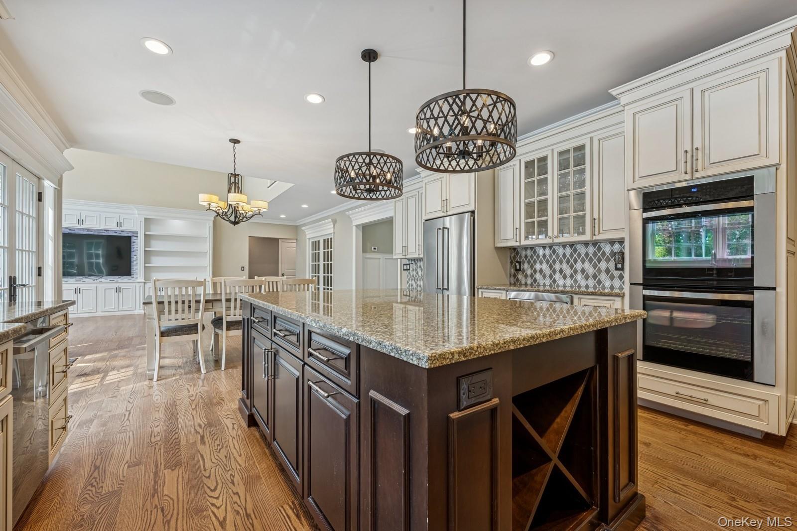 33 Bacon Road St. James, NY 11780 - Photo 15 of 48 a kitchen with stainless steel appliances a large center island attached withe living room