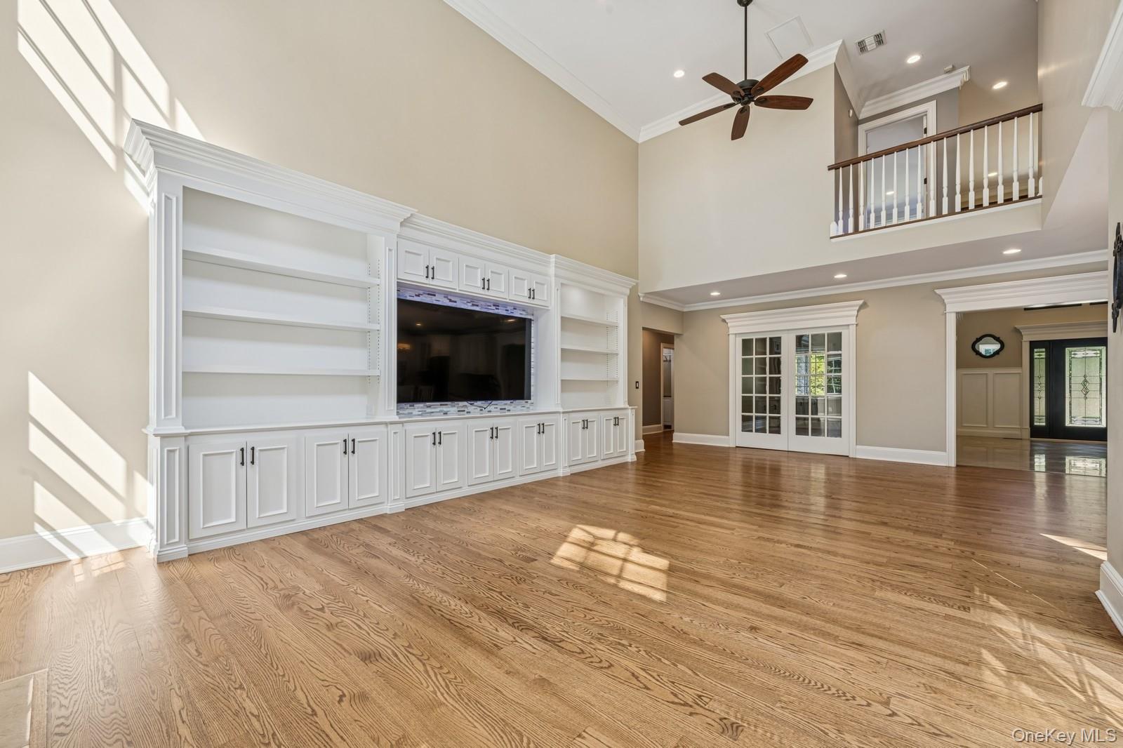 33 Bacon Road St. James, NY 11780 - Photo 19 of 48 a view of a livingroom with wooden floor a ceiling fan and windows