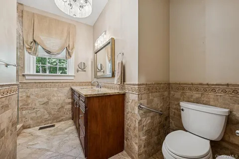 a bathroom with a granite countertop toilet sink and mirror