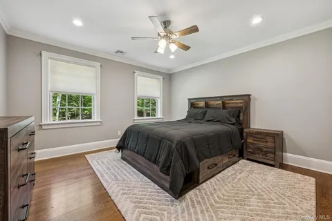 a spacious bedroom with a large bed and a chandelier