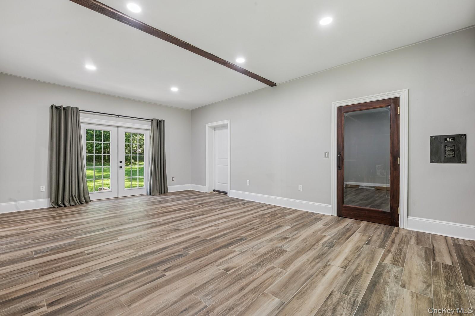 33 Bacon Road St. James, NY 11780 - Photo 38 of 48 a view of an empty room with wooden floor and a window