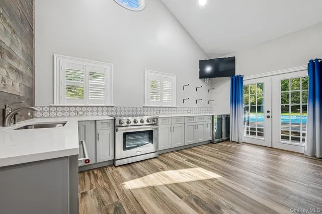 a kitchen with stainless steel appliances a white stove top oven a sink dishwasher and a fireplace with wooden floor