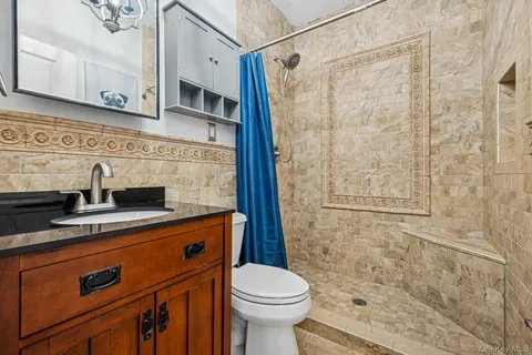 a bathroom with a sink a toilet and shower