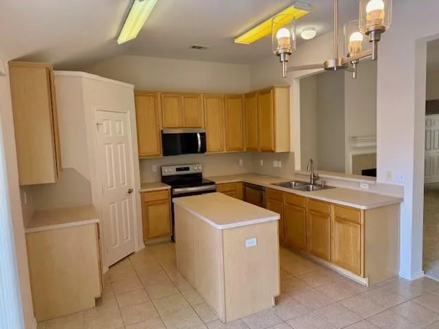 a kitchen that has a sink stainless steel appliances a counter space and a window