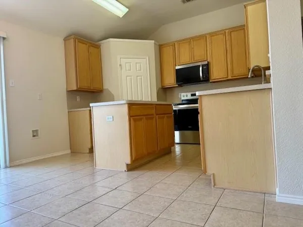a kitchen with a refrigerator and a stove top oven
