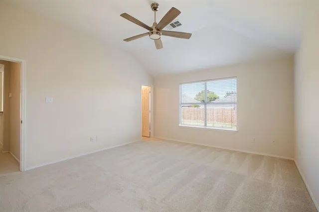 an empty room with a window and a fan