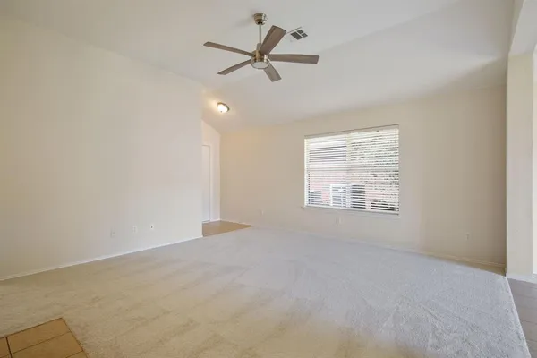 an empty room with a window and a fan