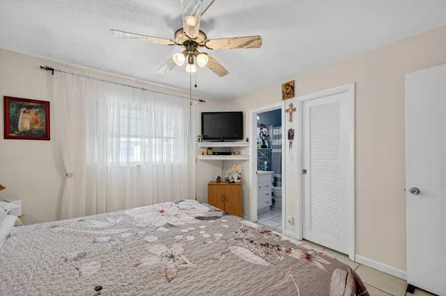 a bedroom with a bed and a flat tv screen on dresser