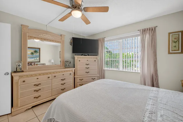 a bedroom with a bed a chandelier and a television