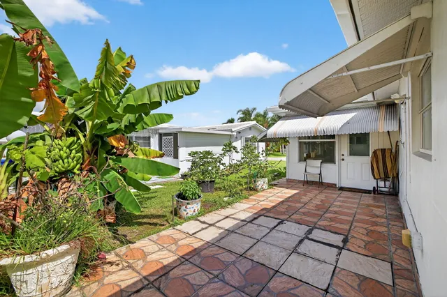 a front view of a house with lots of potted plants