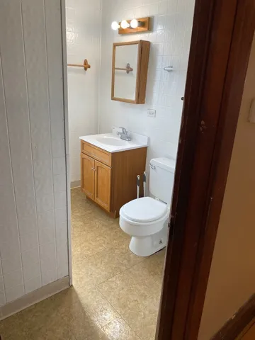 a bathroom with a toilet a sink and mirror