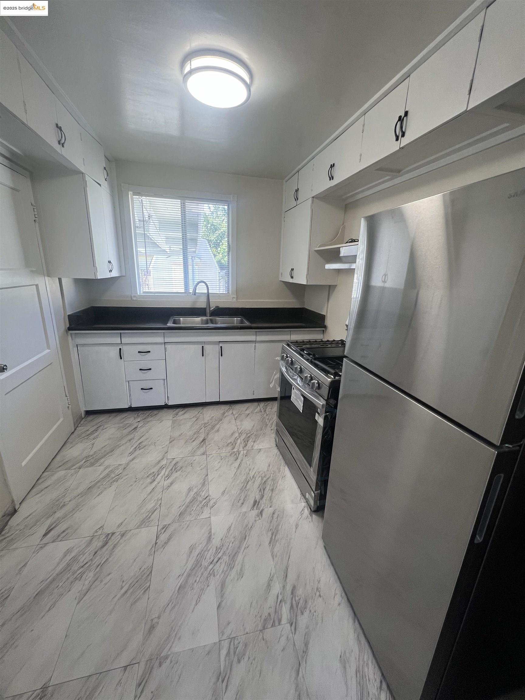 2923 Devon Way San Pablo, CA 94806 - Photo 4 of 11 a kitchen with granite countertop a refrigerator a sink a stove a microwave a counter top and cabinets