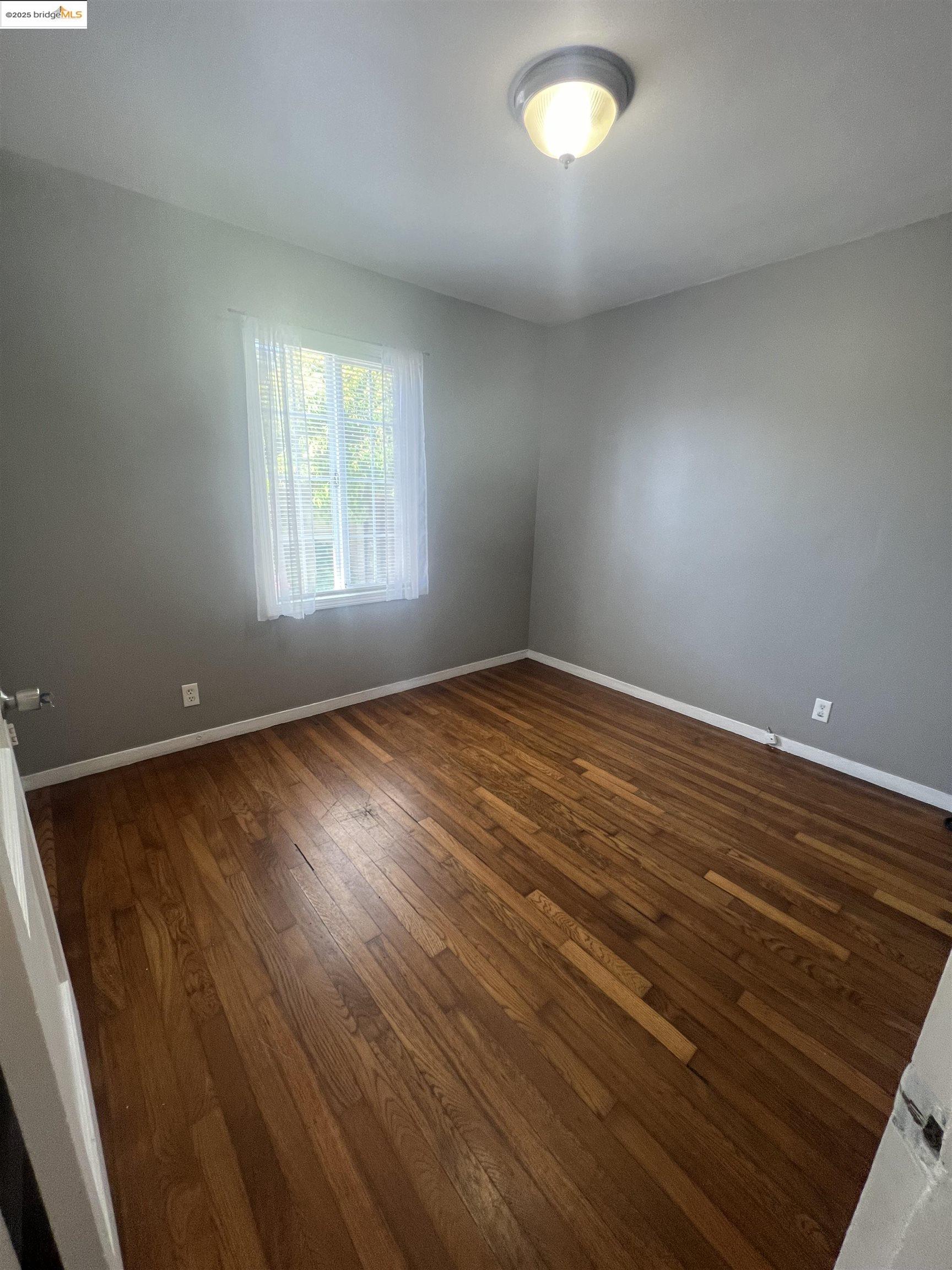 2923 Devon Way San Pablo, CA 94806 - Photo 8 of 11 wooden floor in an empty room with a window