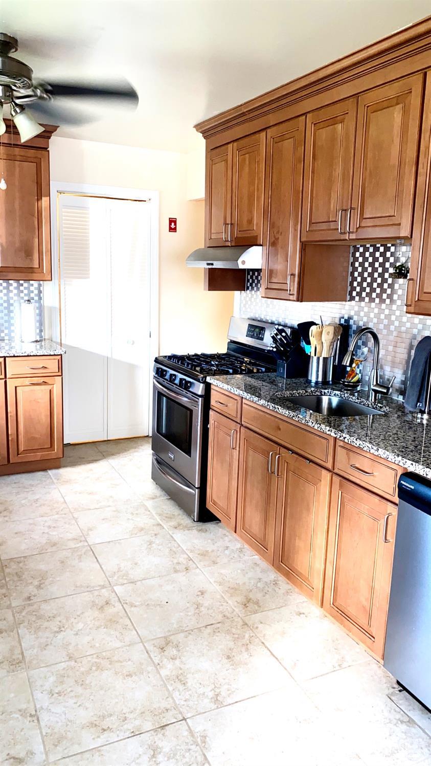 28 Baxter Road Edison, NJ 08817 - Photo 7 of 18 a kitchen with granite countertop a stove a sink dishwasher and a refrigerator