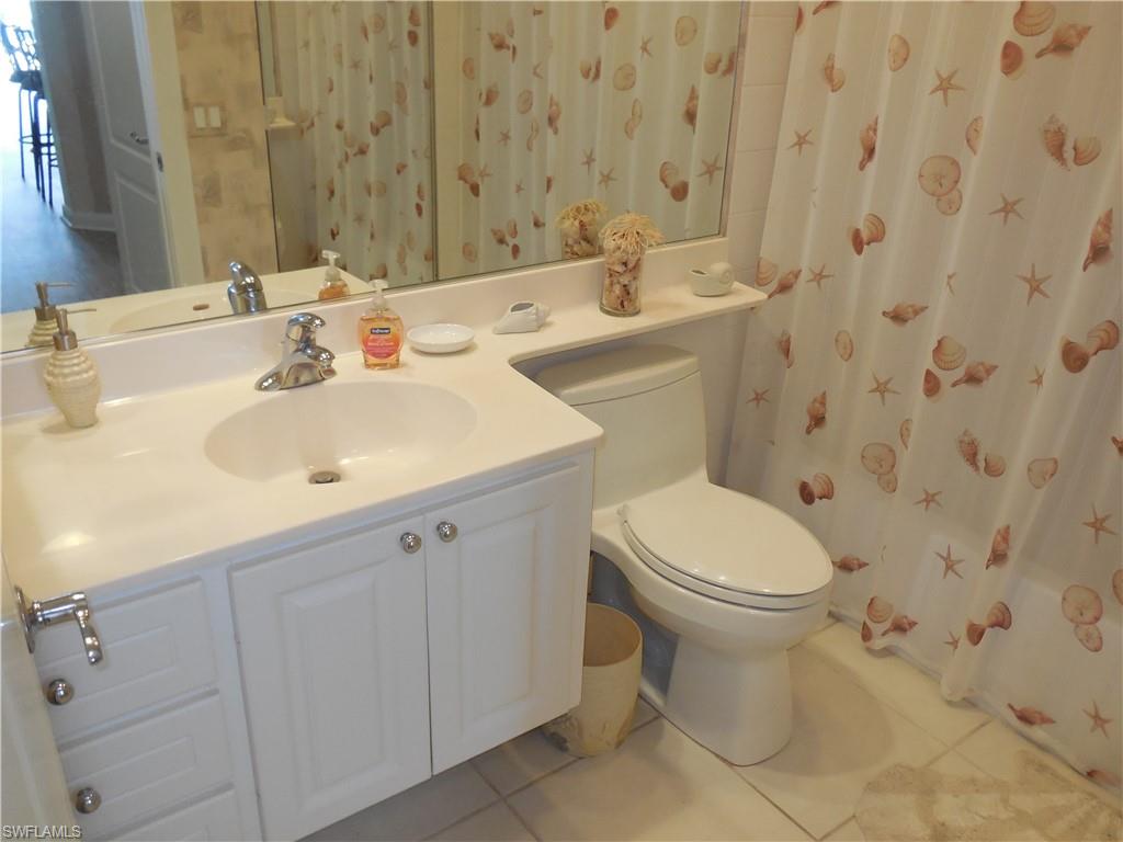 4663 Ossabaw Way Naples, FL 34119 - Photo 17 of 44 Bathroom featuring toilet, tile patterned floors, curtained shower, and vanity