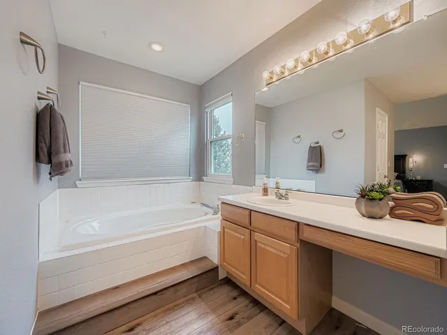 a bathroom with a tub sink and mirror