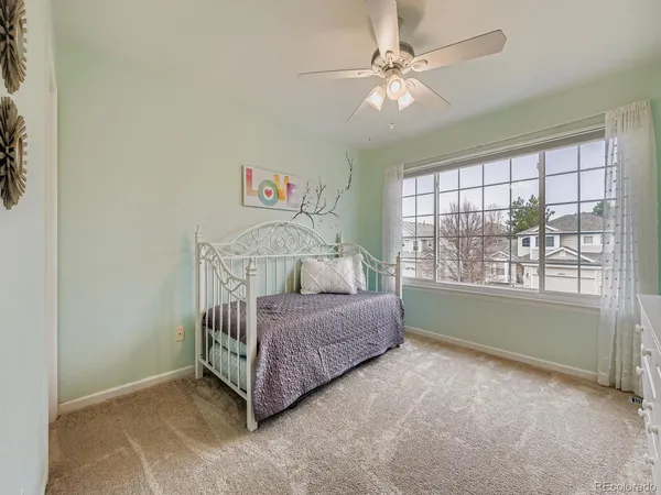 a room with a bed and a chandelier fan