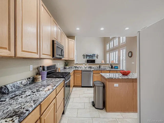 a kitchen with stainless steel appliances granite countertop a stove a sink and a microwave