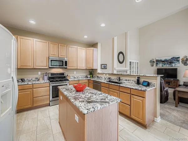 a kitchen with stainless steel appliances granite countertop a stove top oven a sink a counter top space and cabinets