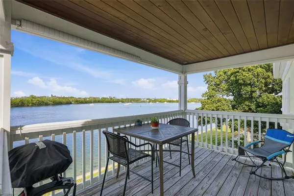 a balcony with wooden floor table and chairs