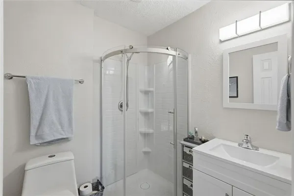a bathroom with a shower a sink and a mirror