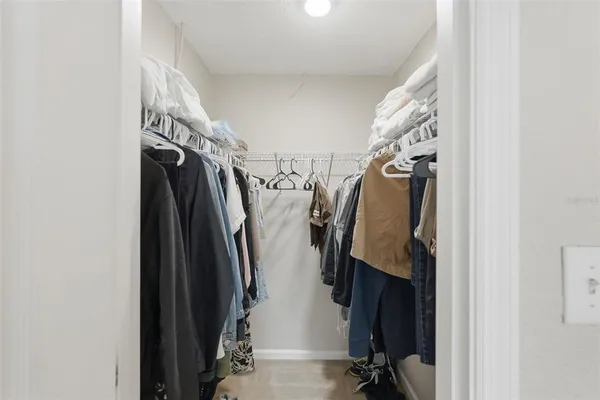 a view of walk in closet with clothes and shoes