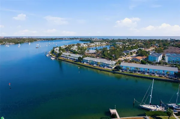 an aerial view of a city with lots of residential buildings ocean and mountain view in back