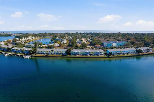 an aerial view of ocean and residential houses with outdoor space