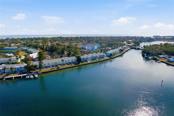 an aerial view of a city with lots of residential buildings ocean and mountain view in back