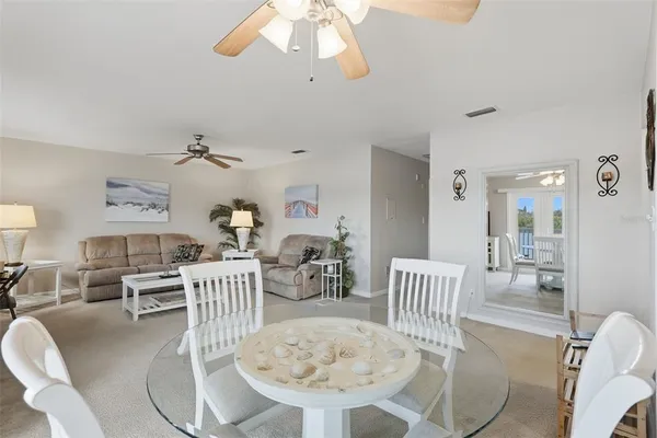 a living room with furniture a dining table and a chandelier