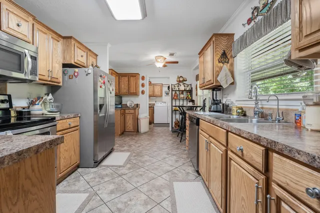 a kitchen with stainless steel appliances granite countertop a refrigerator a sink a stove and dishwasher