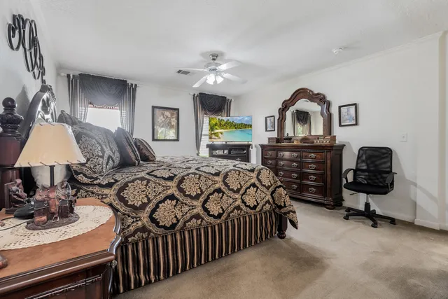 a bedroom with a bed a mirror and lamp on desk