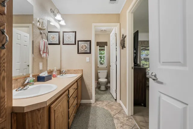 a bathroom with a sink a toilet and shower a mirror