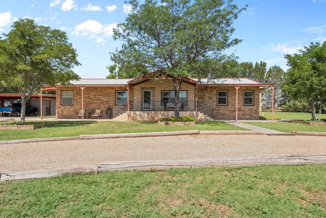 a front view of a house with a yard and outdoor seating